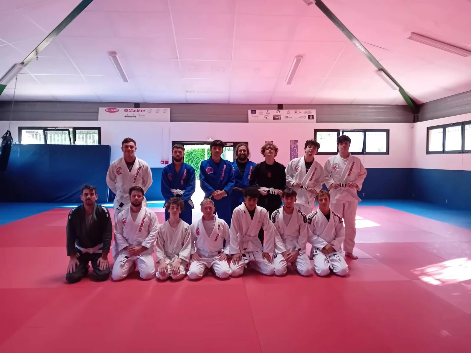Le groupe d'Elite Grapplers Acemat Jiujitsu en kimono, aligné sur les tatamis du dojo d'Aurillac