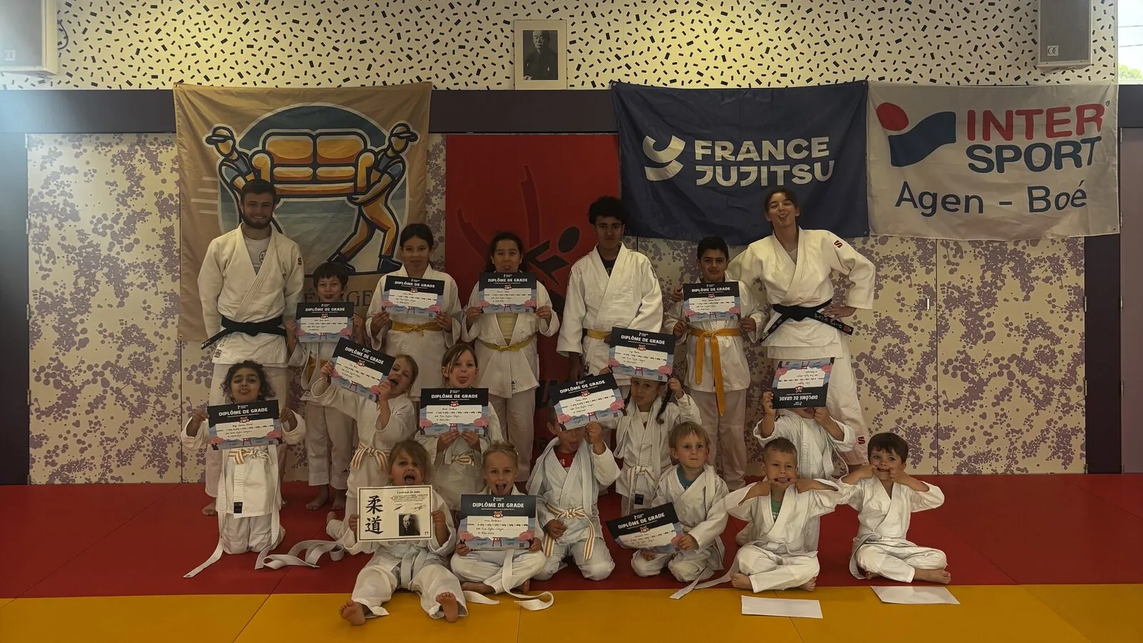 Les enfants de la section judo du Judo Jujitsu Colayrac posant avec leurs diplômes de grade devant la bannière France Jujitsu