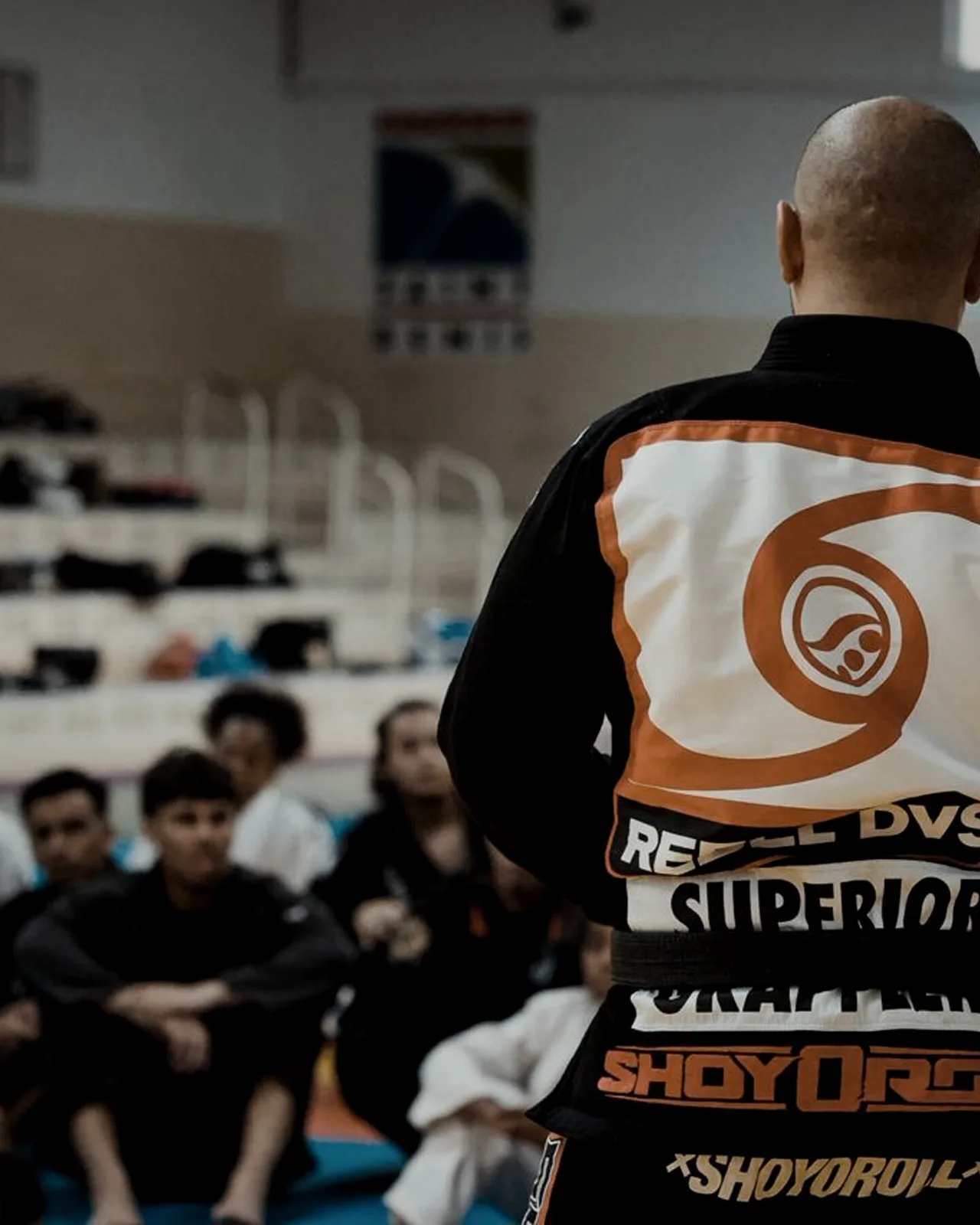 Coach de Foucheroll BJJ en gi devant ses élèves assis sur le tatami, lors d'un stage à La Réunion