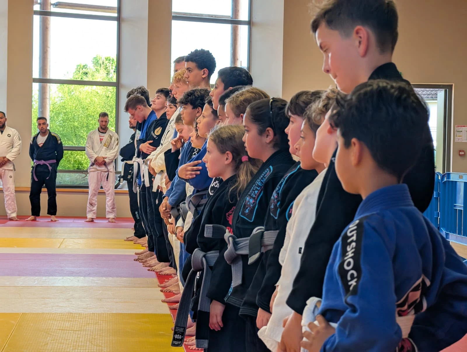 Les élèves d'Horizon Academy alignés en kimono pour le salut de fin de cours, des kids aux ados