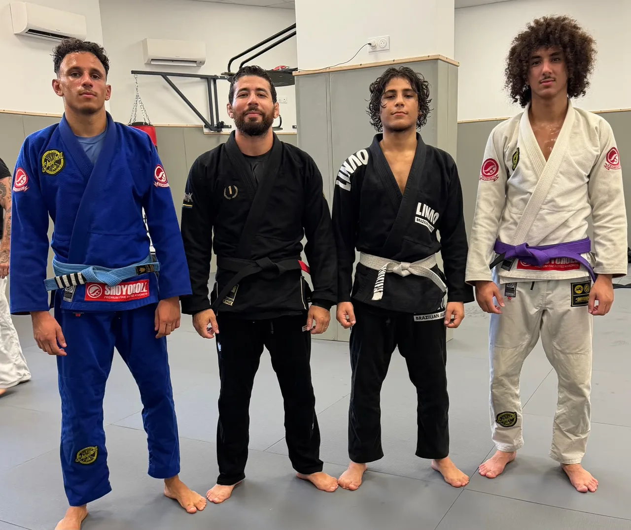 Quatre athlètes du Linao Club alignés sur le tatami de la salle de Nice, Achraf Elhazime en ceinture noire au centre