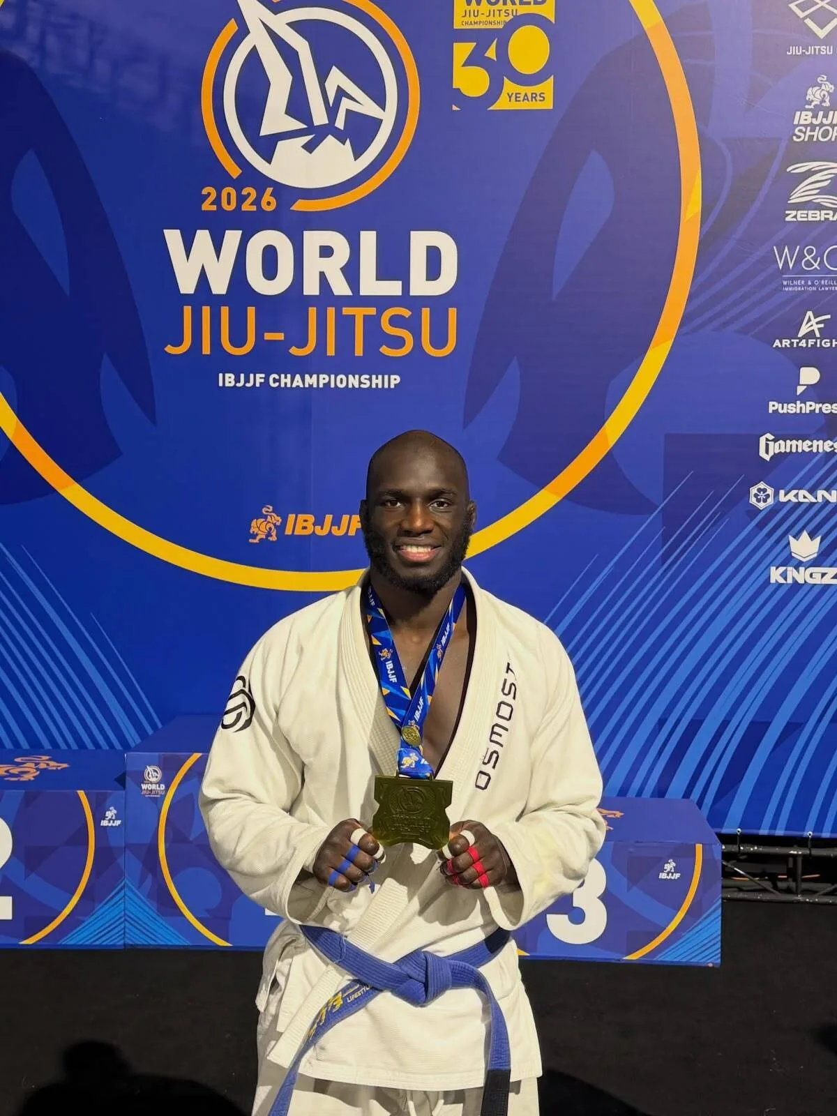 Alassana Touré, ceinture bleue de la MK Team Le Havre, pose avec sa médaille du World Jiu-Jitsu IBJJF 2026 devant le podium de Los Angeles