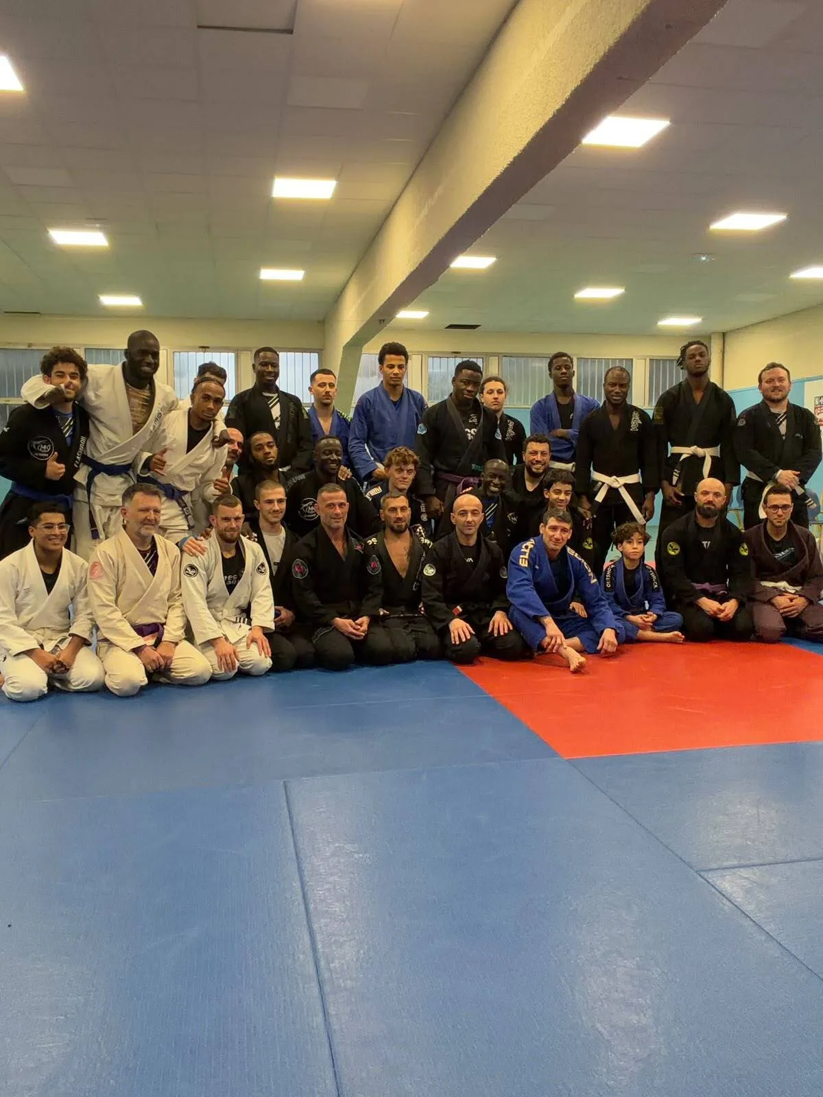 Photo de groupe de la MK Team Le Havre dans son dojo, pratiquants adultes et enfants de toutes ceintures réunis sur le tatami